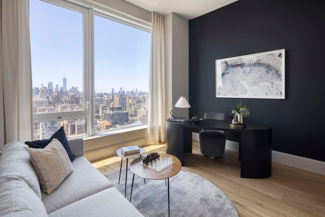 interior space featuring a view of city, baseboards, and wood finished floors