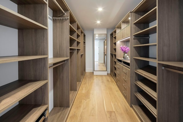 walk in closet with light hardwood / wood-style flooring