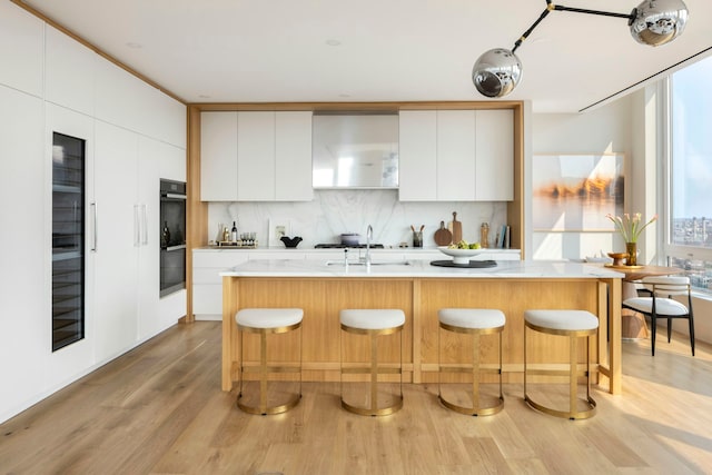 368 3rd Ave Pha, Pha, New York City, NY 10016 - kitchen featuring modern cabinets, light wood finished floors, a sink, light countertops, and a breakfast bar