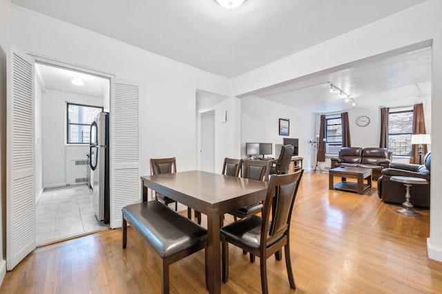 dining space featuring radiator heating unit and light hardwood / wood-style flooring