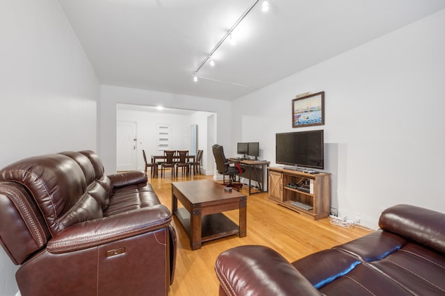 living room featuring rail lighting and light hardwood / wood-style flooring