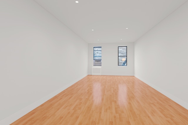 unfurnished room with cooling unit and light hardwood / wood-style floors