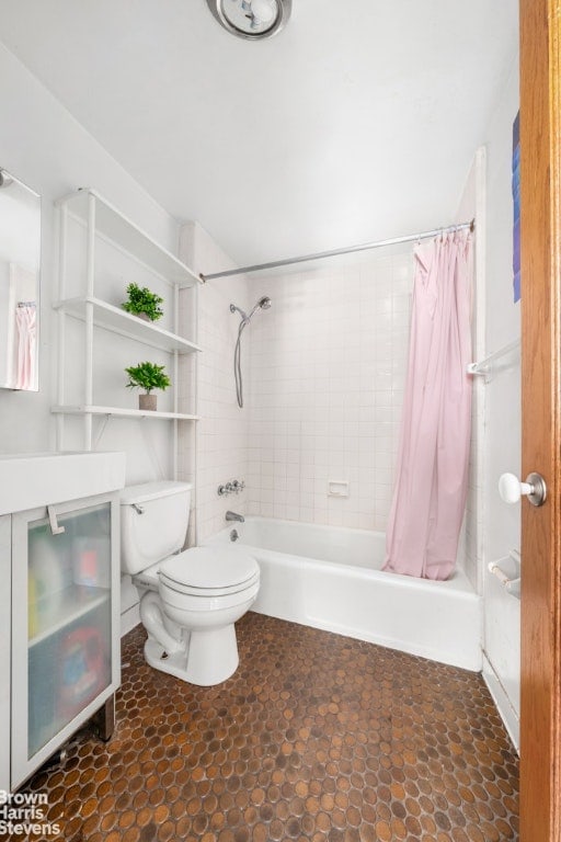 bathroom featuring shower / bath combo with shower curtain and toilet