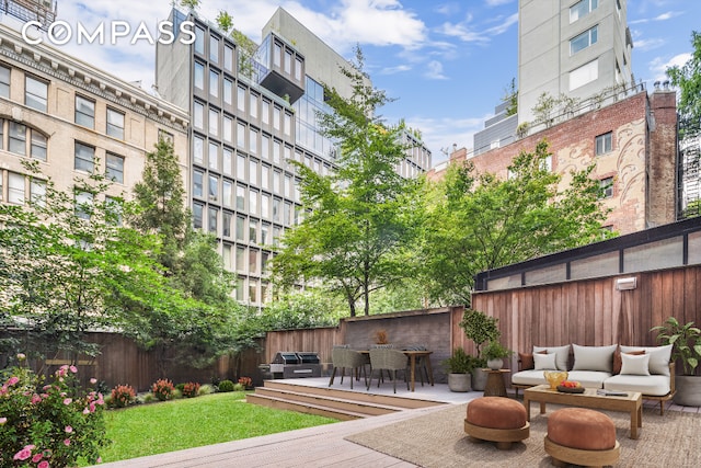 view of community with a deck, outdoor lounge area, and fence private yard