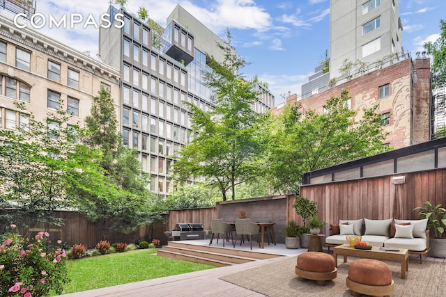 view of community with fence, an outdoor living space, and a wooden deck