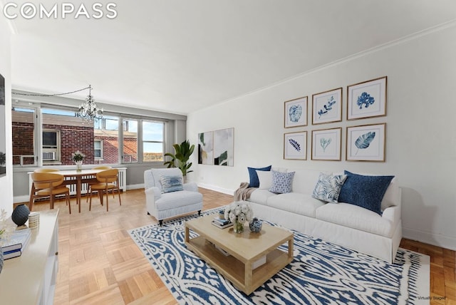 living room with an inviting chandelier, ornamental molding, and light parquet flooring