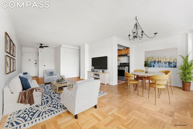 living room featuring ceiling fan with notable chandelier, light parquet flooring, and ornamental molding