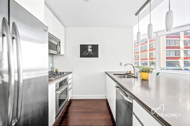 kitchen featuring a sink, baseboards, white cabinets, appliances with stainless steel finishes, and dark wood finished floors