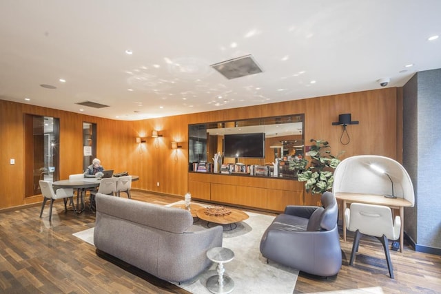 living room featuring wooden walls, recessed lighting, and wood finished floors