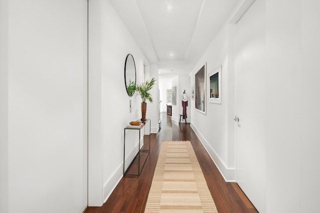 hall featuring dark wood finished floors and baseboards