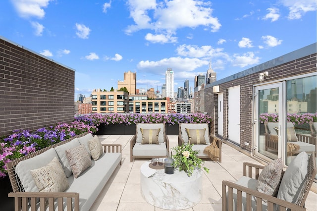 view of patio / terrace with a city view, a balcony, and an outdoor hangout area