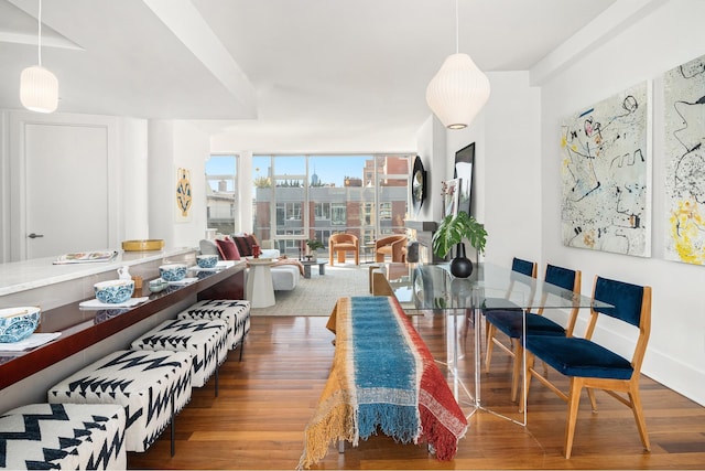 dining space with floor to ceiling windows, baseboards, and wood finished floors