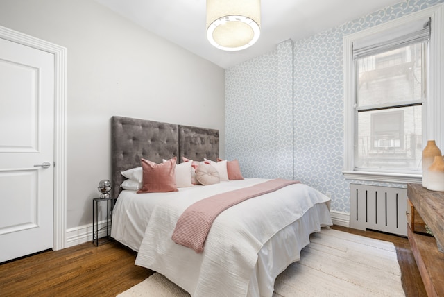 bedroom featuring radiator and hardwood / wood-style floors