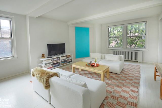 living area featuring baseboards, beamed ceiling, radiator heating unit, and wood finished floors