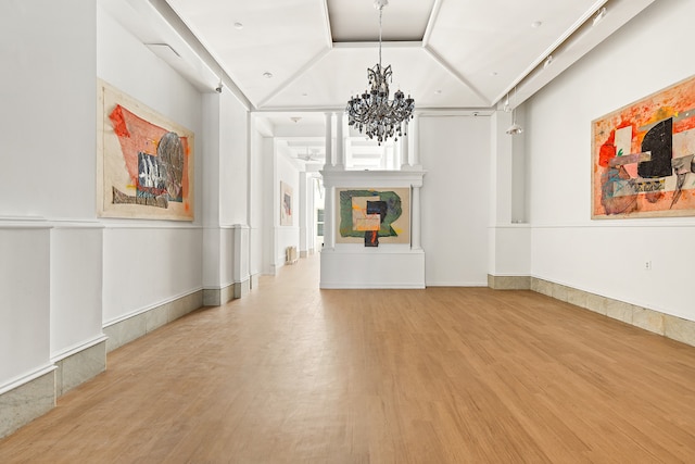 31 Greene St Unit 1, New York City, NY 10013 - unfurnished living room with wood finished floors, a chandelier, and vaulted ceiling