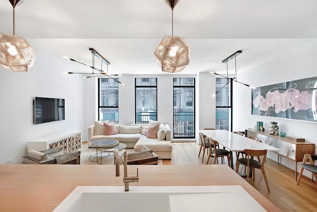 living room featuring a notable chandelier and light wood-type flooring