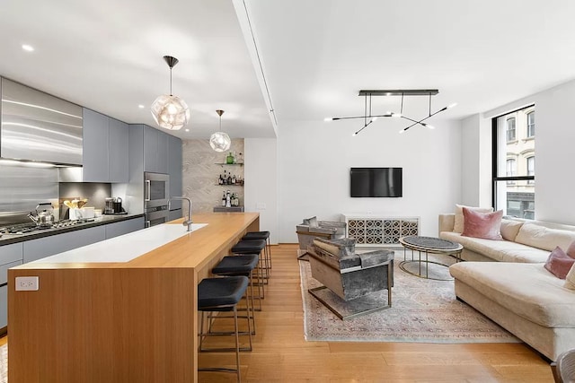 71 Reade St Unit 2B, New York City, NY 10007 - living room with light wood-style flooring and a chandelier