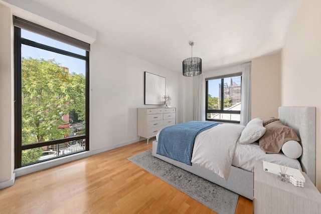 bedroom featuring wood-type flooring and a notable chandelier