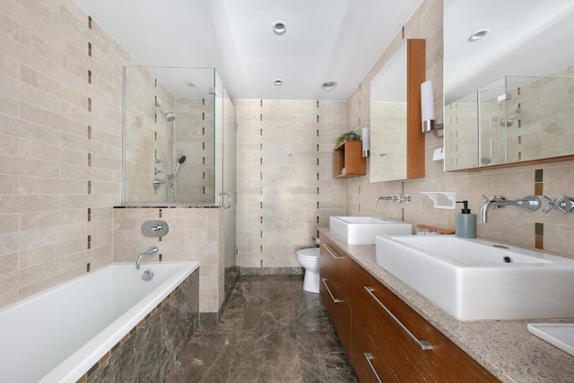 full bathroom with tile walls, toilet, vanity, and independent shower and bath