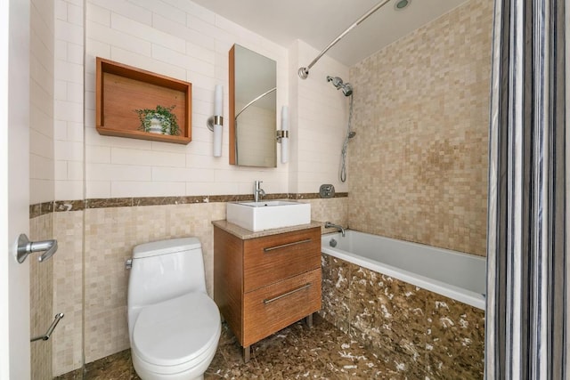 full bathroom with toilet, tiled shower / bath combo, tile walls, and vanity