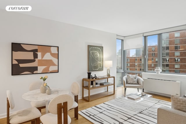 living area featuring light wood finished floors, baseboards, a view of city, and visible vents