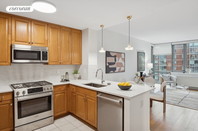425 Main St Unit 14A, New York City, NY 10044 - kitchen featuring appliances with stainless steel finishes, tasteful backsplash, light countertops, and a peninsula