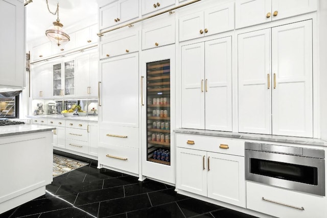 kitchen with dark tile patterned flooring, white cabinetry, hanging light fixtures, gas cooktop, and stainless steel microwave