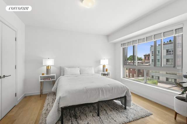 bedroom featuring light wood-type flooring, visible vents, and baseboards