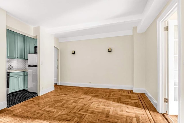 49 W 72nd St Unit 6E, New York City, NY 10023 - kitchen with stainless steel fridge, decorative backsplash, light parquet floors, green cabinetry, and beam ceiling