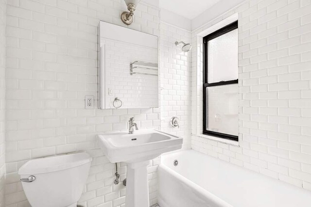 49 W 72nd St Unit 6E, New York City, NY 10023 - bathroom with tile walls, tiled shower / bath, and toilet