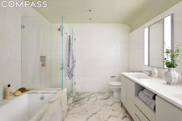 full bathroom featuring vanity, toilet, separate shower and tub, and tile walls