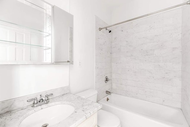 full bathroom with tiled shower / bath, vanity, and toilet