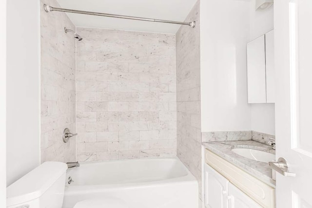 full bathroom featuring tiled shower / bath, vanity, and toilet