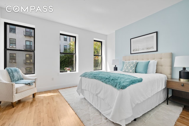 bedroom with baseboards and light wood finished floors