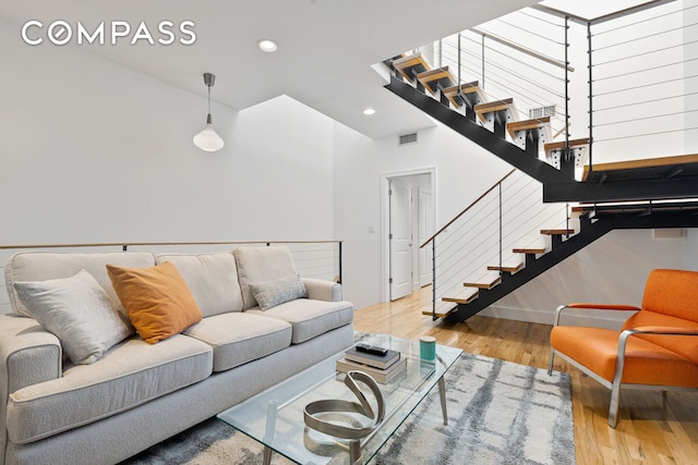 living room with stairs, recessed lighting, visible vents, and wood finished floors