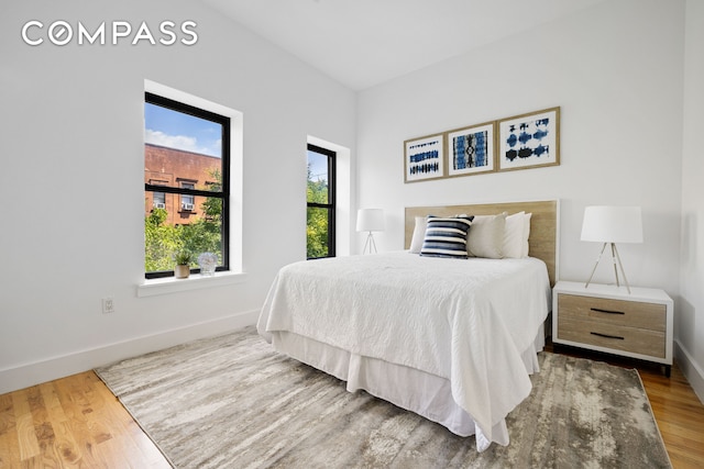 bedroom with baseboards and wood finished floors