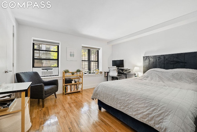 bedroom with cooling unit and light wood-type flooring