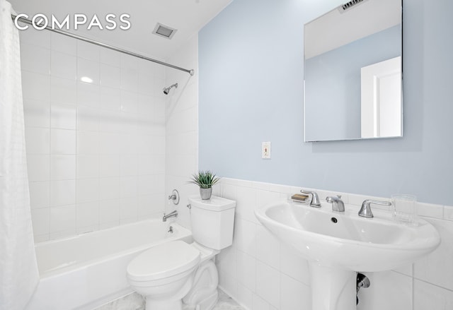 full bath with toilet, shower / bath combo, visible vents, and tile walls