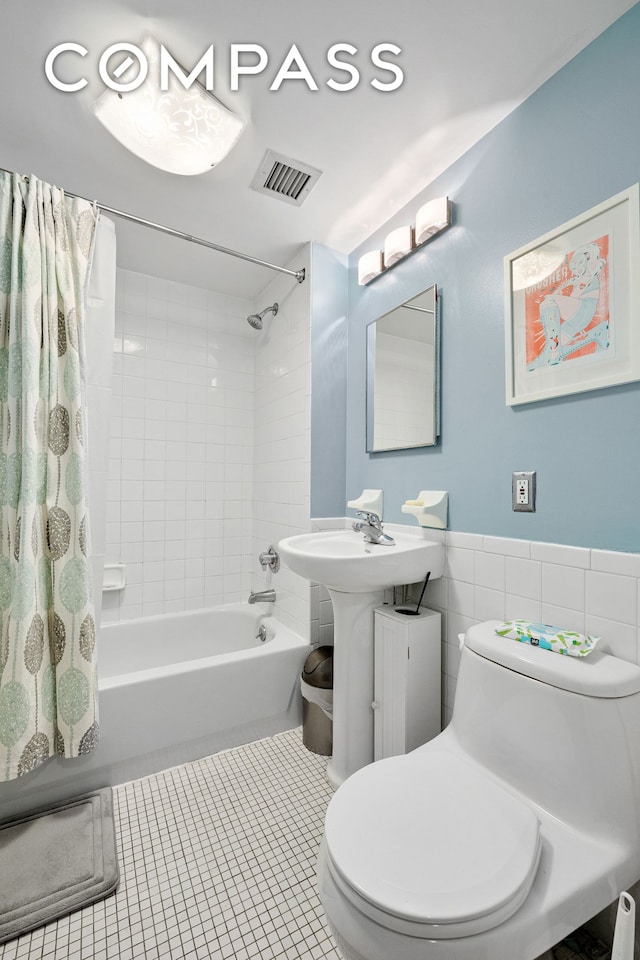 full bathroom featuring shower / bath combo, visible vents, toilet, tile patterned flooring, and tile walls