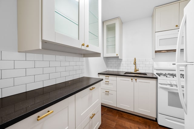 kitchen with white cabinetry, tasteful backsplash, white appliances, dark wood-type flooring, and sink