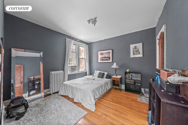 living room with crown molding, track lighting, hardwood / wood-style floors, and a notable chandelier