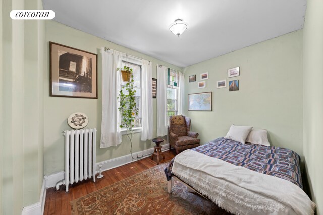 living room with wood-type flooring, track lighting, and crown molding