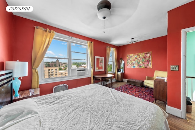 bedroom with cooling unit, hardwood / wood-style floors, and ceiling fan