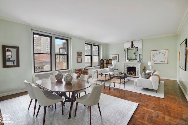 dining space with dark parquet flooring and crown molding