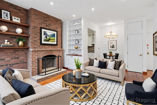 146 W 82nd St Unit 3A, New York City, NY 10024 - living room with wood finished floors, built in features, a chandelier, a brick fireplace, and recessed lighting