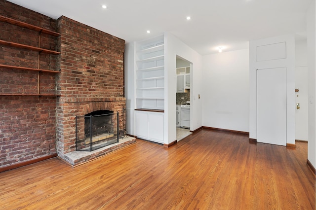 146 W 82nd St Unit 3A, New York City, NY 10024 - unfurnished living room with a brick fireplace, wood finished floors, baseboards, and recessed lighting