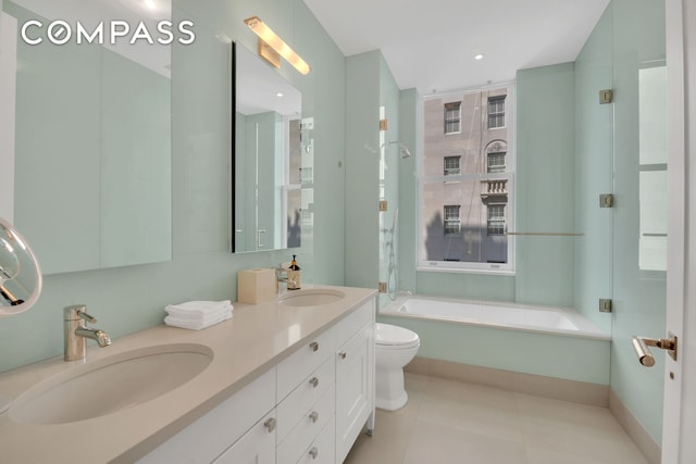 bathroom featuring tile patterned flooring, double vanity, toilet, and a sink