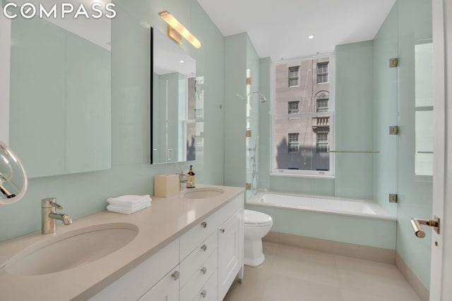 bathroom featuring tile patterned flooring, vanity, a washtub, and toilet