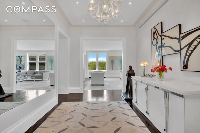 hallway with a notable chandelier, ornamental molding, wood finished floors, recessed lighting, and baseboards