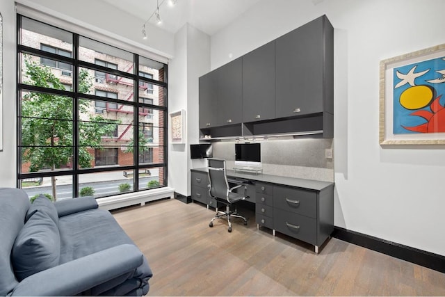 office area featuring built in desk, light wood-type flooring, and a wealth of natural light